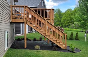 Second story stained wood deck with stairway to back yard - side view