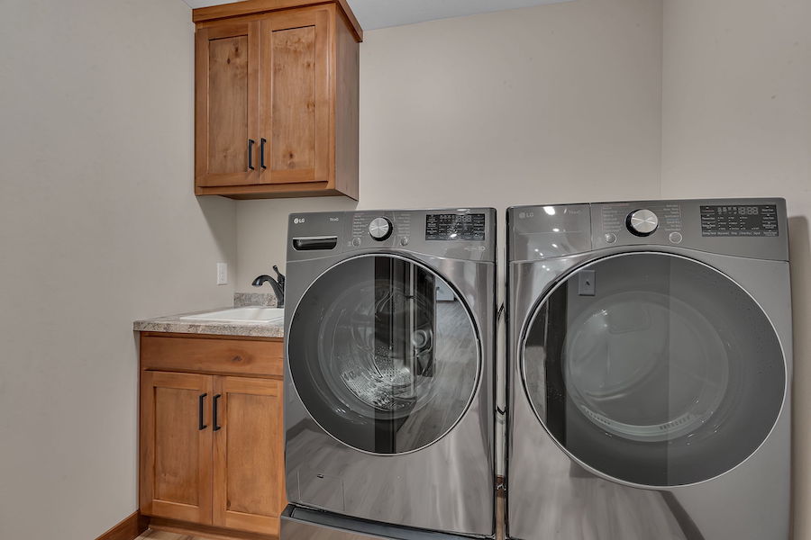 Utility room with sink, cabinets and washer/dryer set