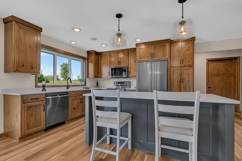 Custom kitchen with large gray island and wood cabinetry
