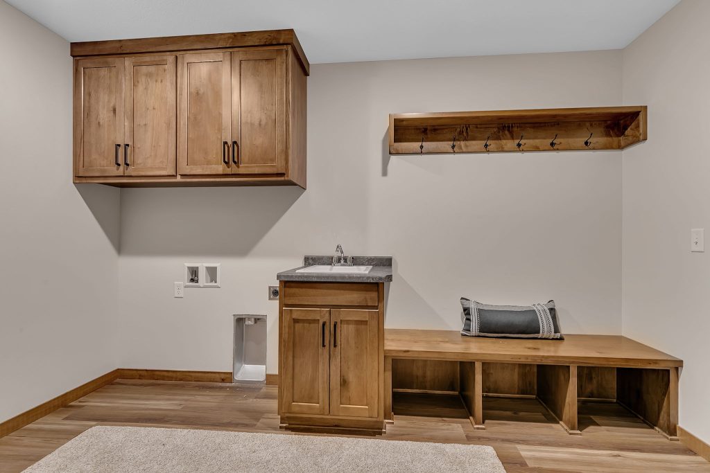 Mudroom with sink cabinetry bench and coat hooks